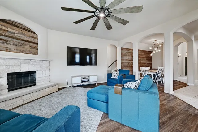 a living room with furniture a flat screen tv and a fireplace