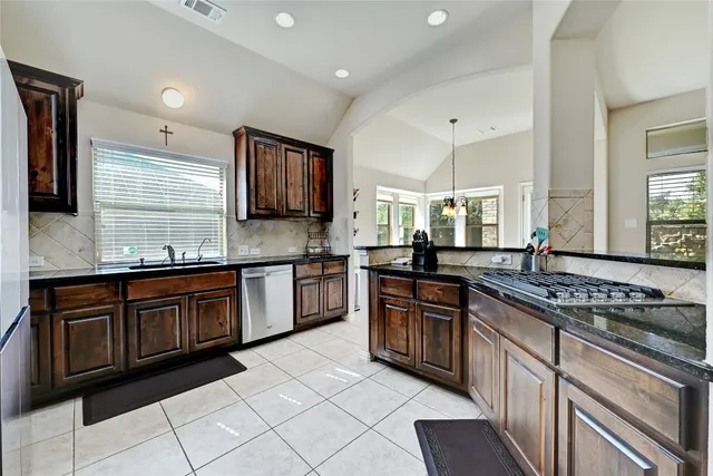 a kitchen with stainless steel appliances granite countertop a stove sink and cabinets