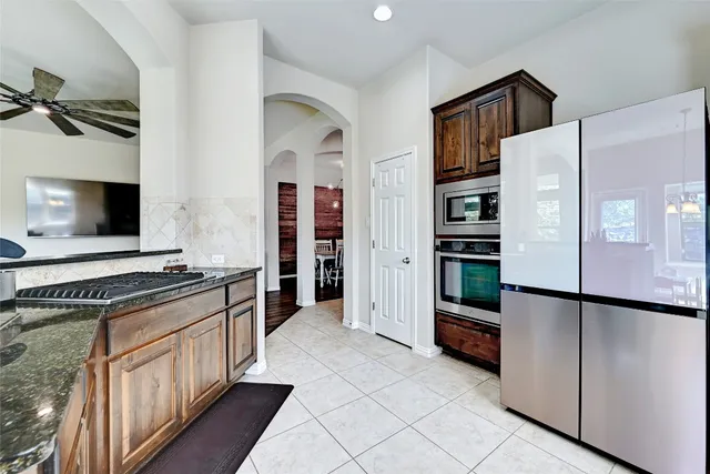 a kitchen with stainless steel appliances a refrigerator and a stove top oven