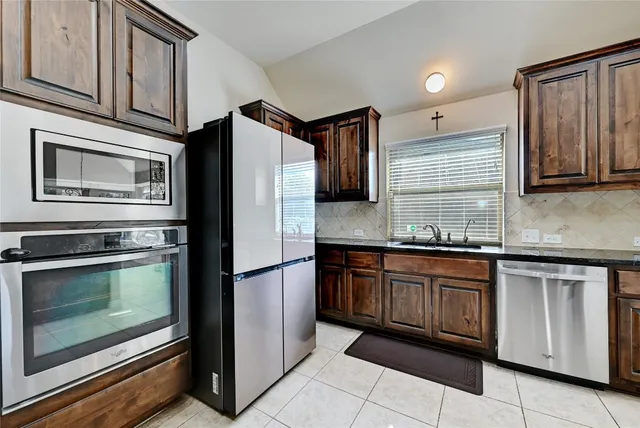 a kitchen with granite countertop stainless steel appliances and wooden cabinets