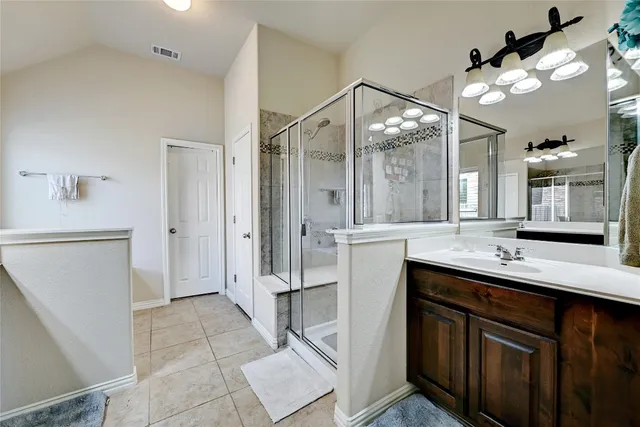 a bathroom with a double vanity sink mirror and cabinets