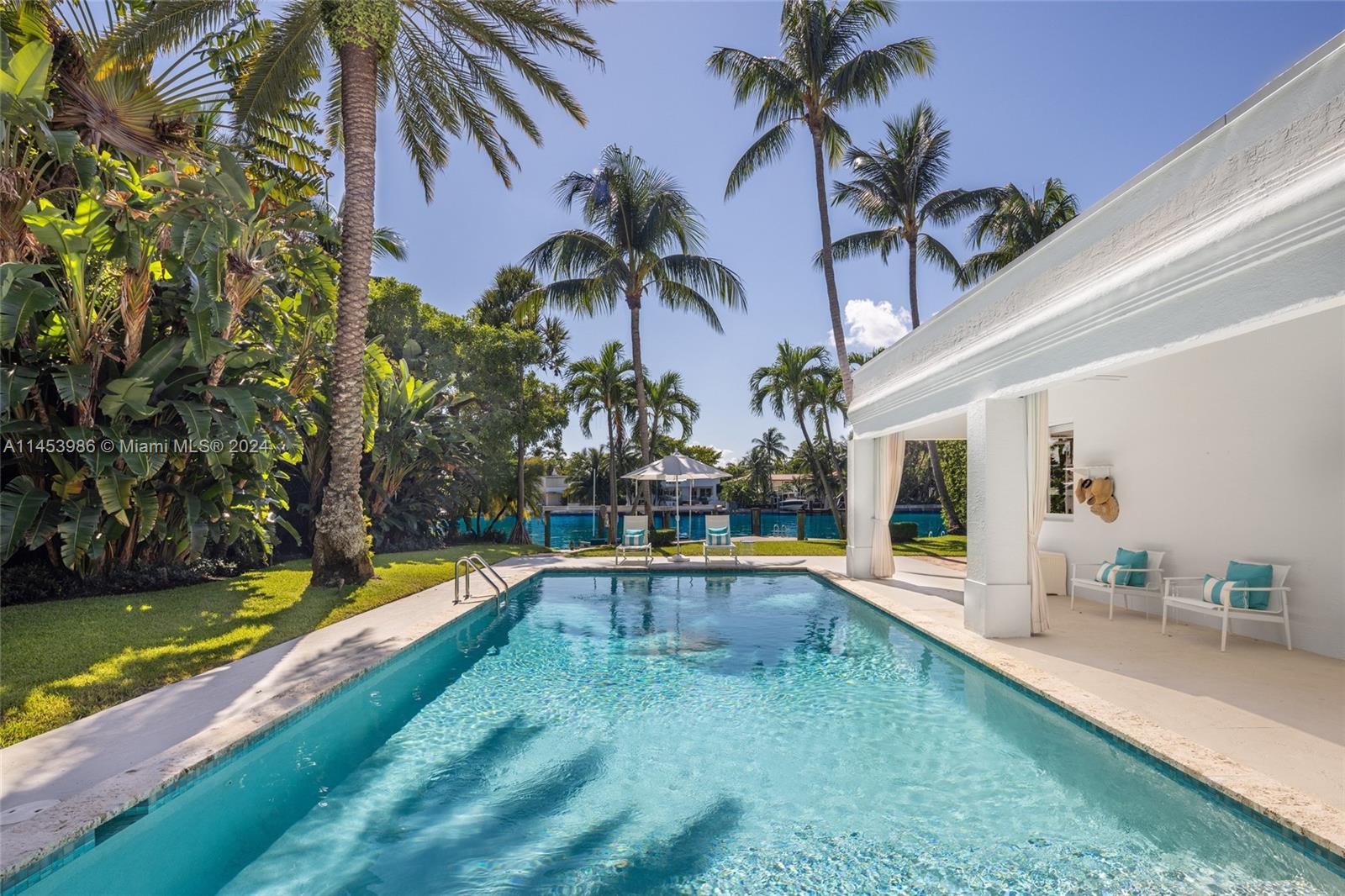 6350 Allison Road Miami Beach, FL 33141 - Photo 40 of 57 a view of swimming pool with a lawn chairs under an umbrella