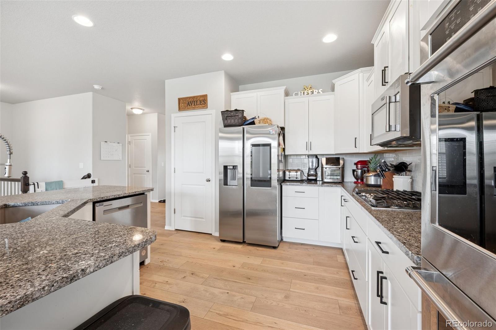 12846 Granite Ridge Drive Peyton, CO 80831 - Photo 12 of 32 a kitchen with stainless steel appliances granite countertop a refrigerator and a sink