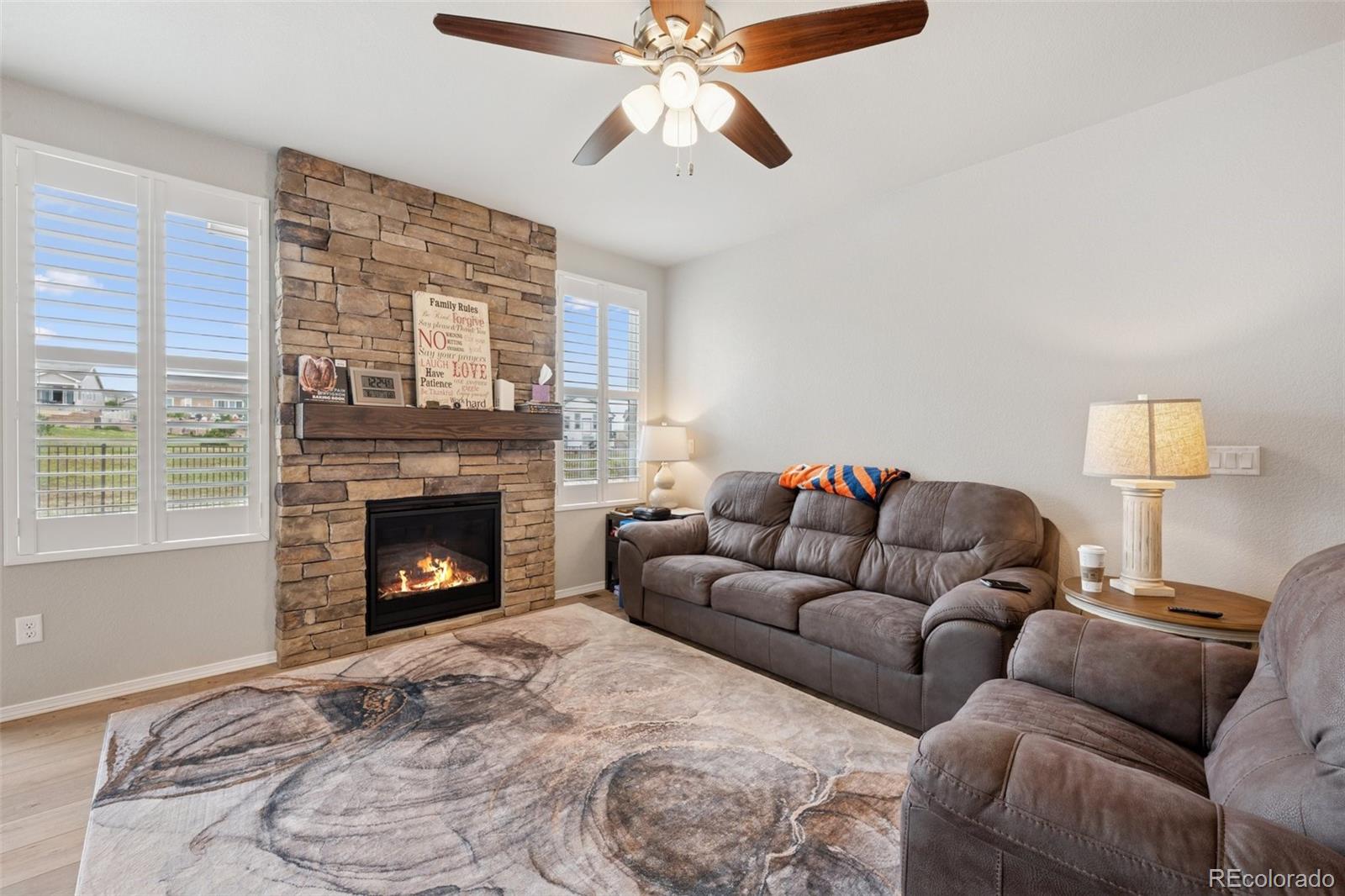 12846 Granite Ridge Drive Peyton, CO 80831 - Photo 15 of 32 a living room with furniture a flat screen tv and a fireplace