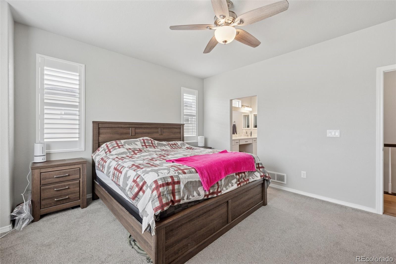 12846 Granite Ridge Drive Peyton, CO 80831 - Photo 18 of 32 a bed room with a bed and a chandelier