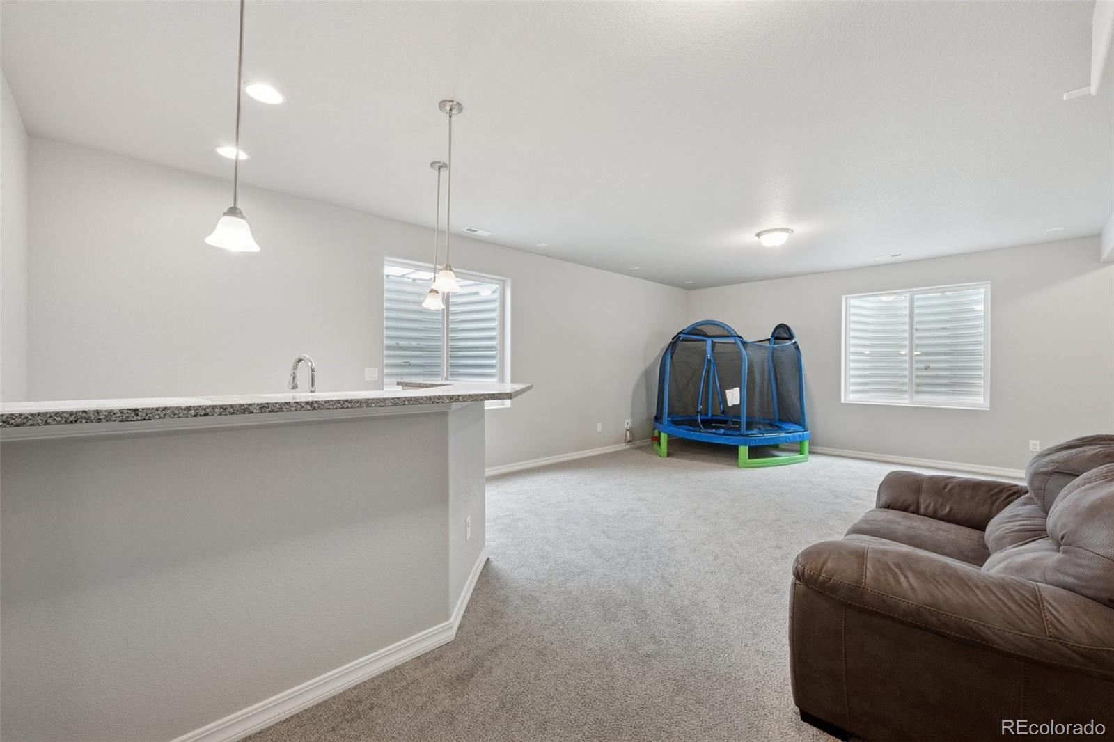 12846 Granite Ridge Drive Peyton, CO 80831 - Photo 24 of 32 a living room with furniture a window and a chandelier
