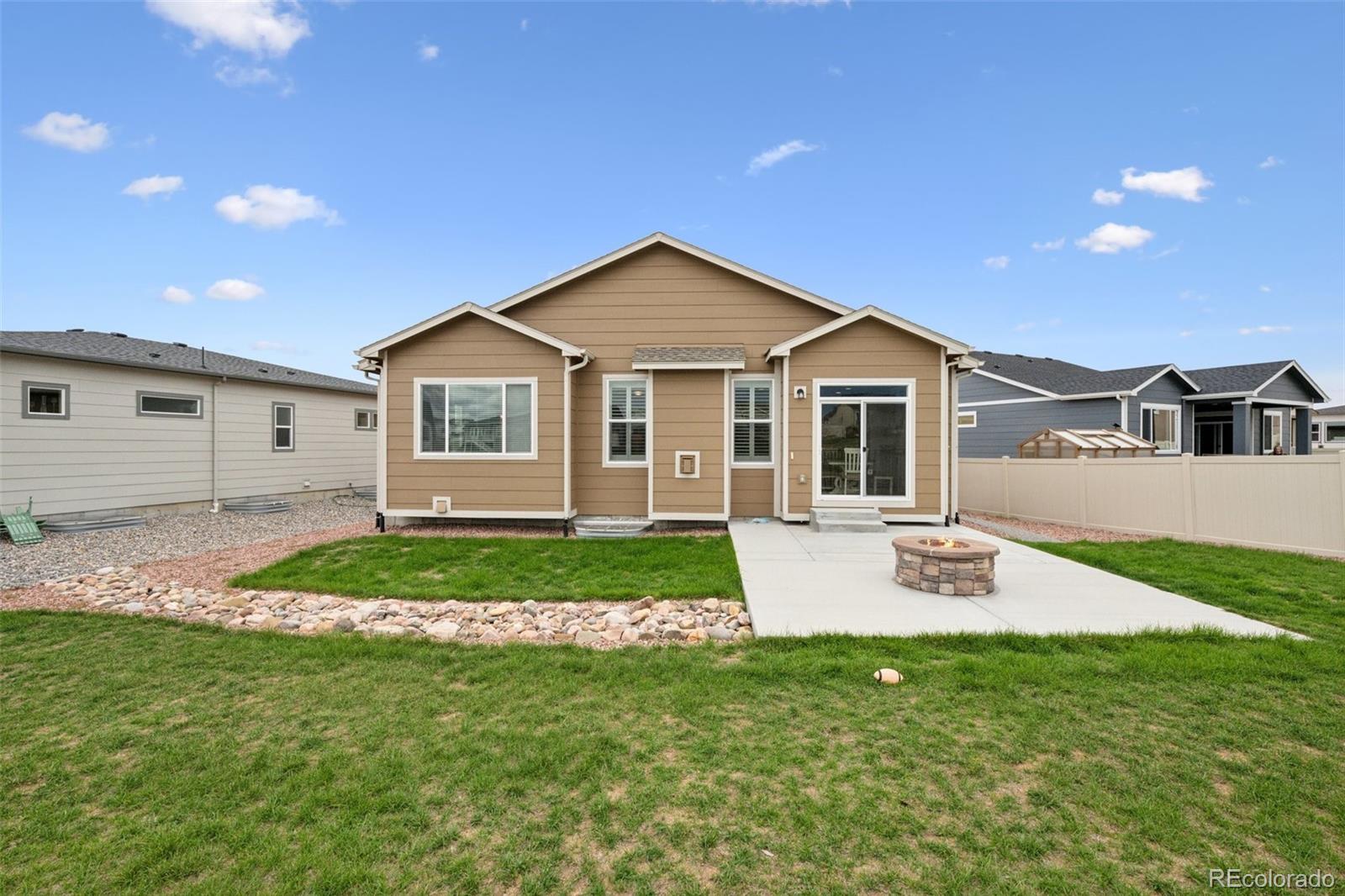 12846 Granite Ridge Drive Peyton, CO 80831 - Photo 5 of 32 a front view of a house with a garden and yard