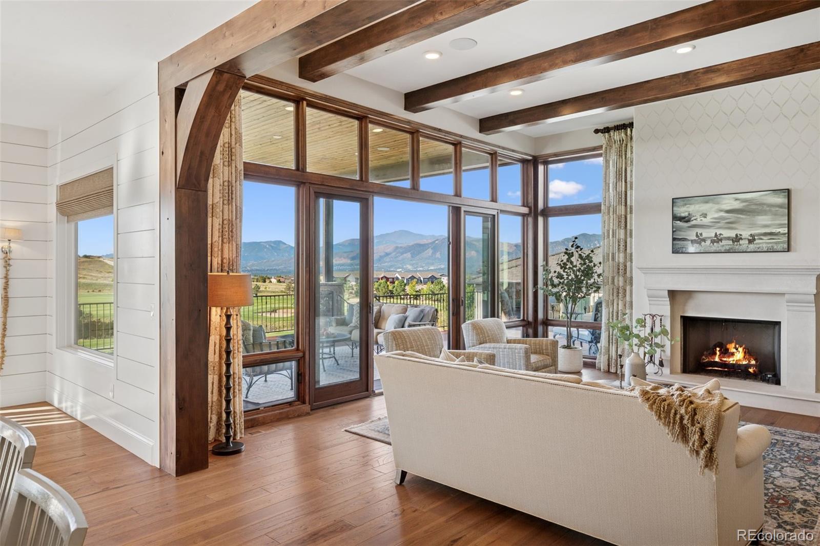 12846 Granite Ridge Drive Peyton, CO 80831 - Photo 8 of 32 a living room with furniture fireplace and floor to ceiling windows