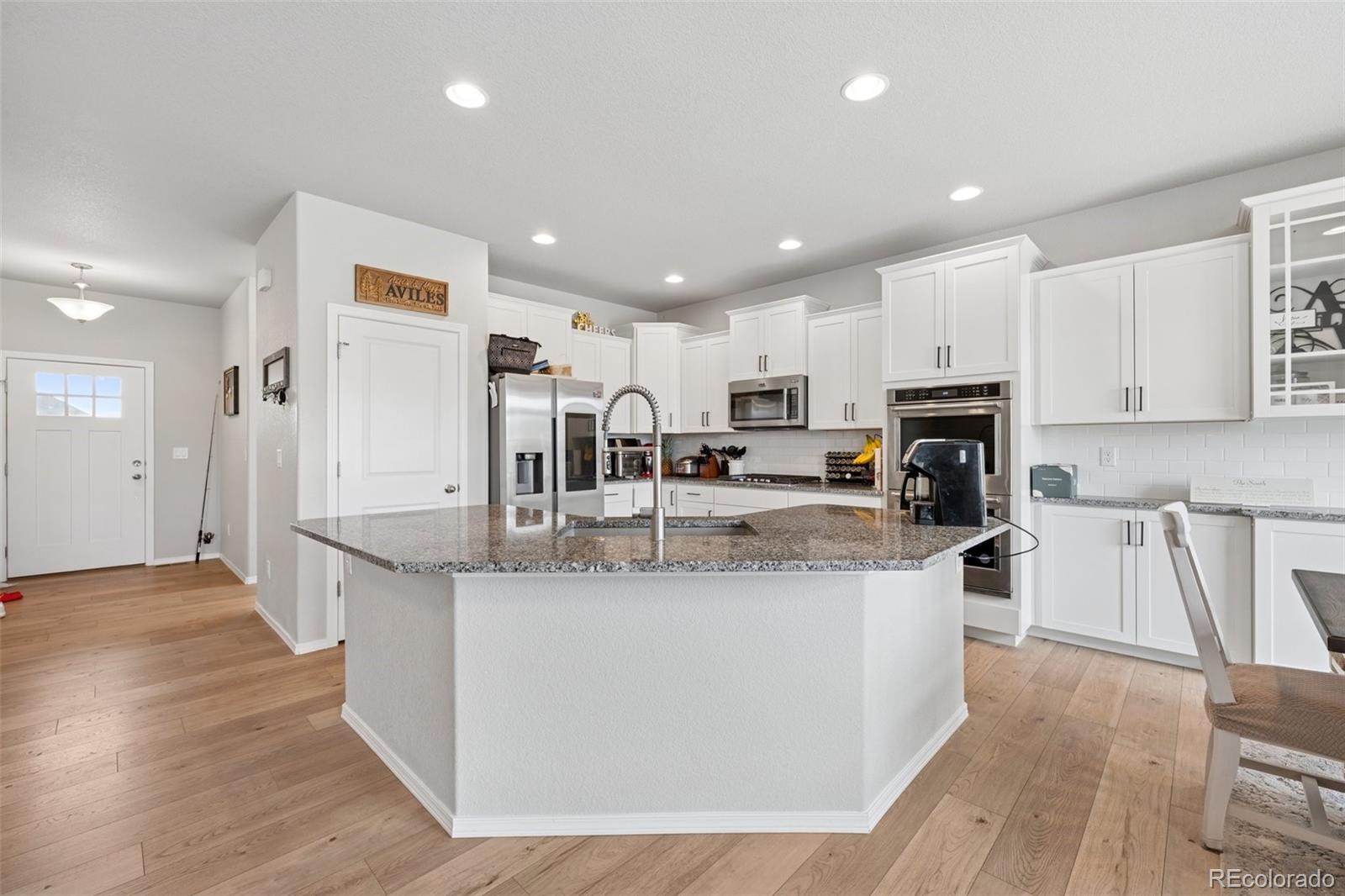12846 Granite Ridge Drive Peyton, CO 80831 - Photo 10 of 32 a large kitchen with stainless steel appliances lots of counter top space