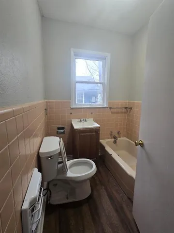 a white toilet sitting next to a bathroom sink and tub