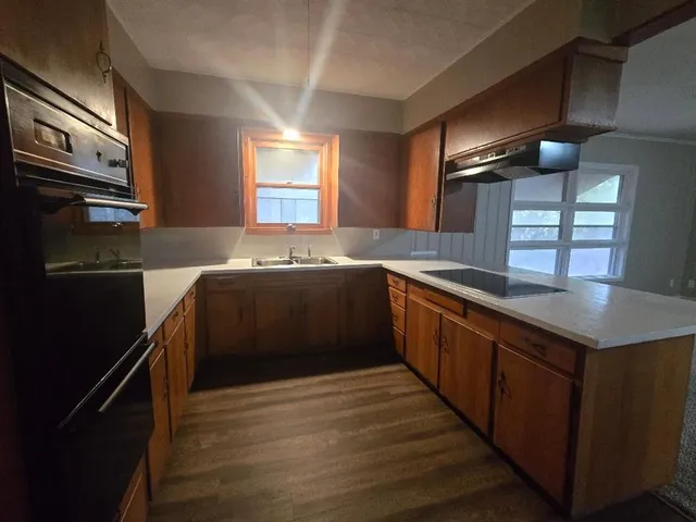 a kitchen with stainless steel appliances granite countertop a sink a stove and a refrigerator