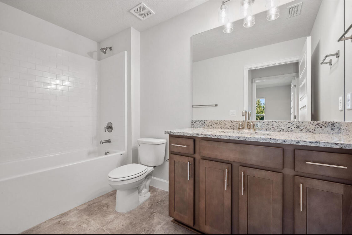 5536 Lugo Street Fort Pierce, FL 34951 - Photo 11 of 33 a bathroom with a granite countertop toilet a sink and a bathtub
