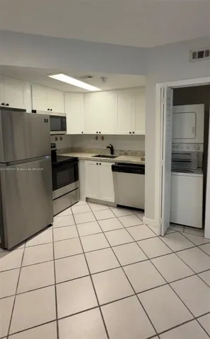 a kitchen with granite countertop a refrigerator and a sink