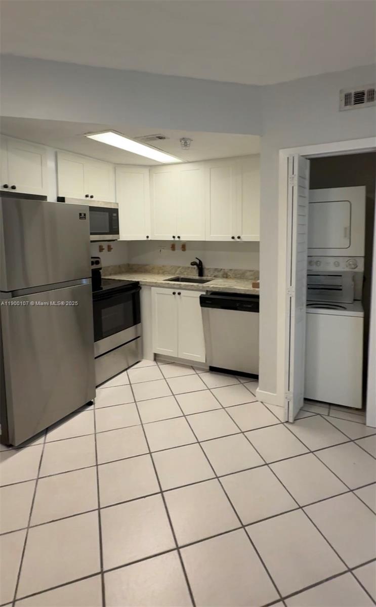3051 Southwest 27th Avenue, Unit 402 Miami, FL 33133 - Photo 2 of 5 a kitchen with granite countertop a refrigerator and a sink