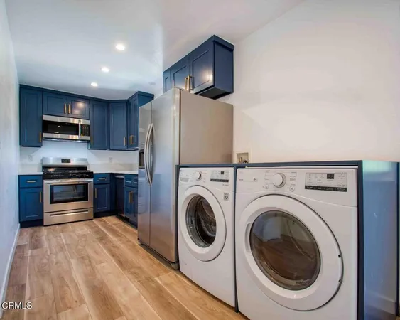 a kitchen with stainless steel appliances a refrigerator a stove top oven a sink and dishwasher