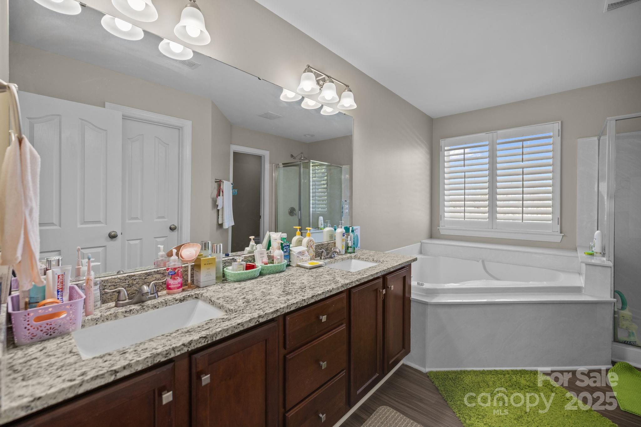 6416 Baltray Road Charlotte, NC 28278 - Photo 20 of 34 a bathroom with a granite countertop sink a large mirror and a bathtub