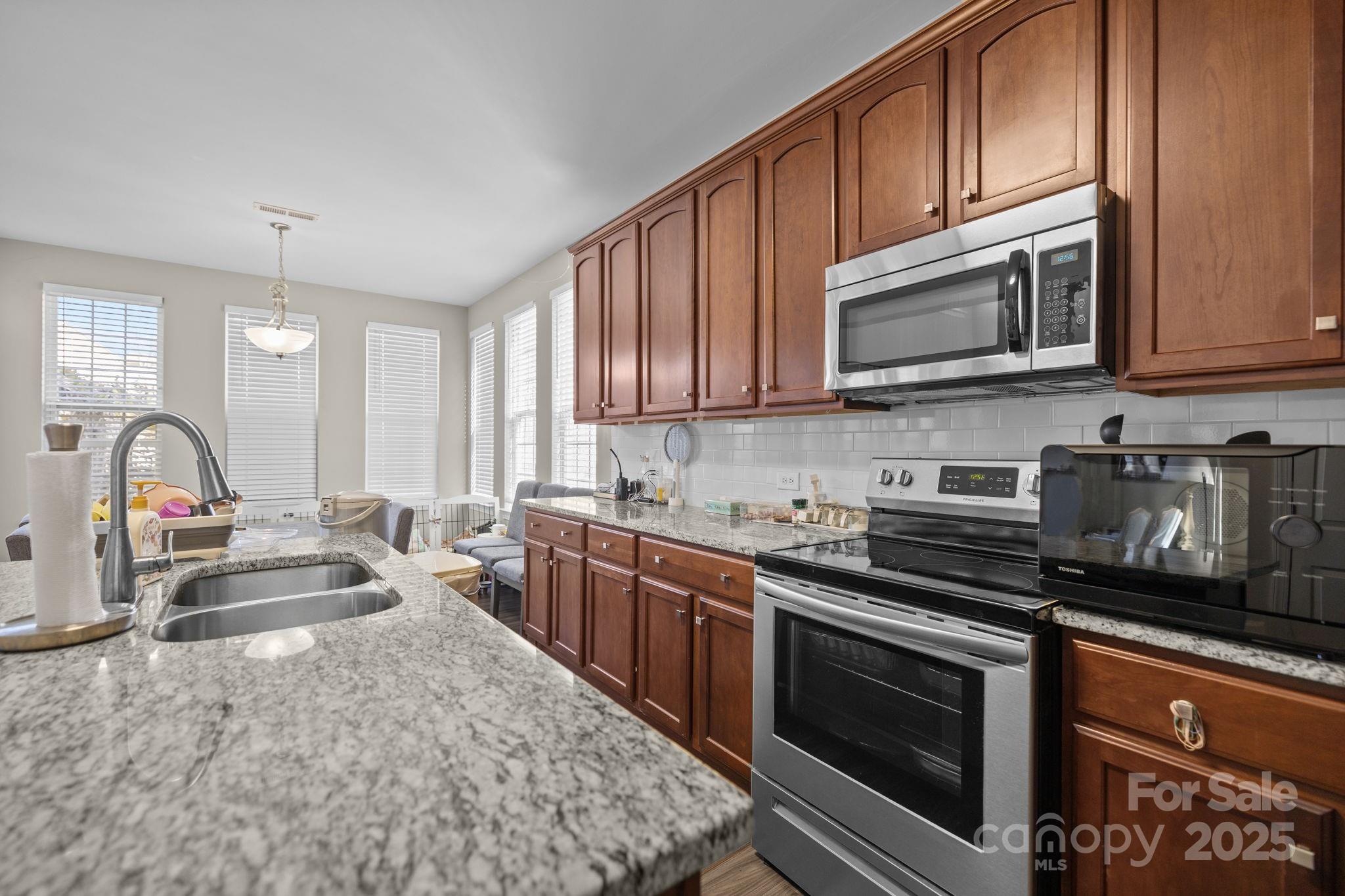 6416 Baltray Road Charlotte, NC 28278 - Photo 7 of 34 a kitchen with stainless steel appliances granite countertop a stove sink microwave and cabinets