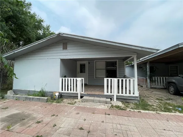 a view of a house with a yard and wooden fence