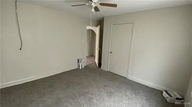 an empty room with a ceiling fan and a window