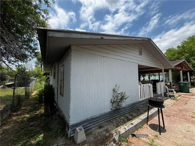 a backyard of a house with table and chairs