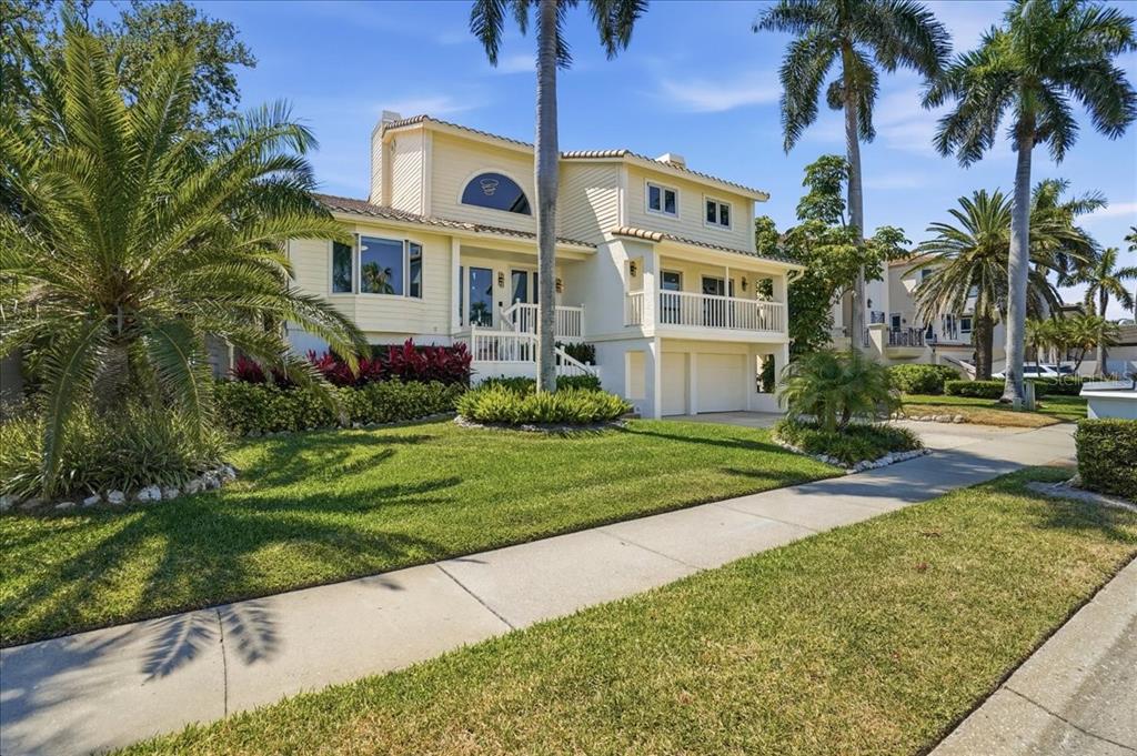 3481 Bayou Sound Longboat Key, FL 34228 - Photo 2 of 79 a front view of a house with a yard and potted plants