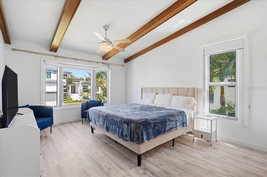3481 Bayou Sound Longboat Key, FL 34228 - Photo 27 of 79 a bedroom with a large bed a flat screen tv and windows