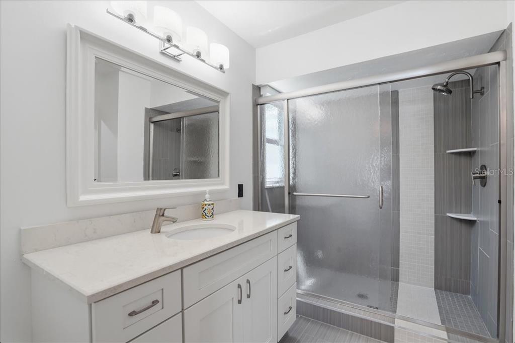 3481 Bayou Sound Longboat Key, FL 34228 - Photo 29 of 79 a bathroom with a shower sink vanity and mirror