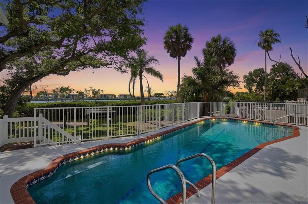 3481 Bayou Sound Longboat Key, FL 34228 - Photo 5 of 79 a view of a swimming pool with a garden and trees