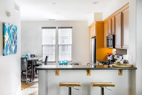 a kitchen with stainless steel appliances granite countertop a stove and a white cabinets