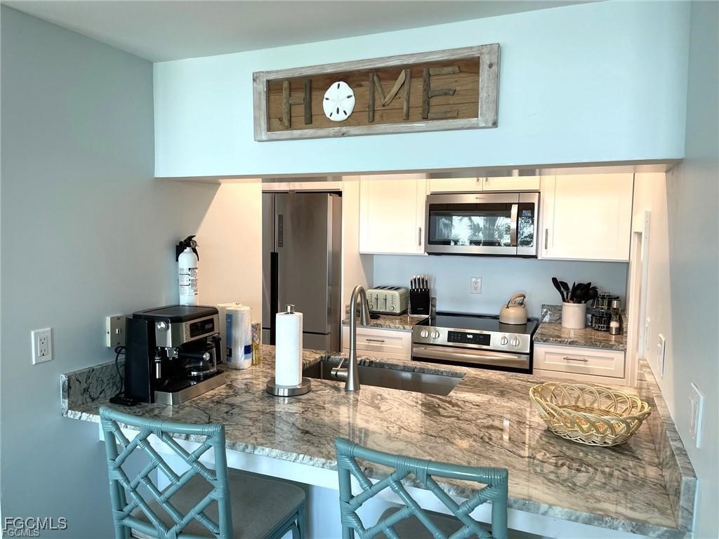640 Gulf Lane, Unit 3 Captiva, FL 33924 - Photo 27 of 50 a kitchen with stainless steel appliances a stove a sink and a microwave