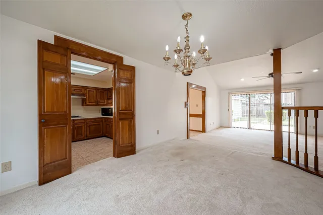 a view of a hallway with wooden floor and a kitchen