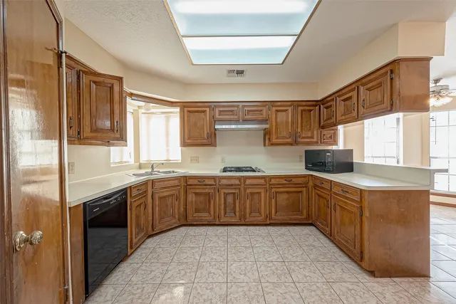a large kitchen with stainless steel appliances granite countertop a sink and cabinets