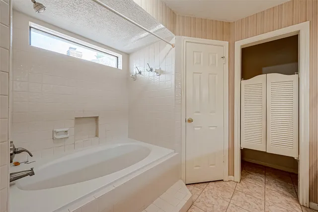 a spacious bathroom with a tub sink shower and mirror