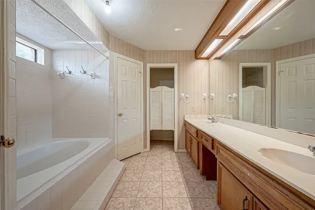 a spacious bathroom with a tub shower and sink