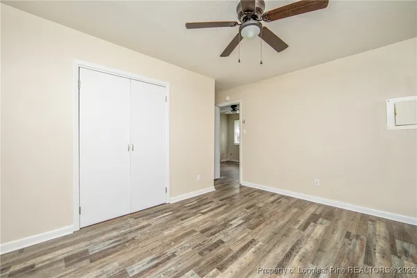 a view of a room with wooden floor closet and a ceiling fan