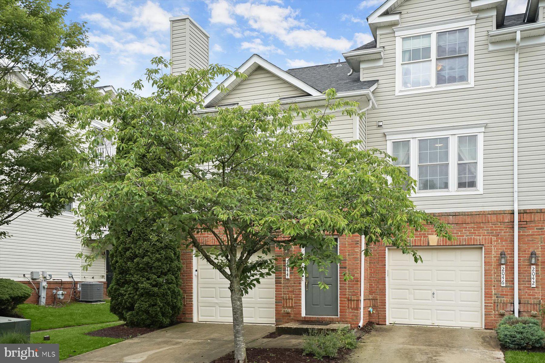 2044 Astilbe Way, Unit 2044 Odenton, MD 21113 - Photo 1 of 56 a small garden in front of a house with a tree