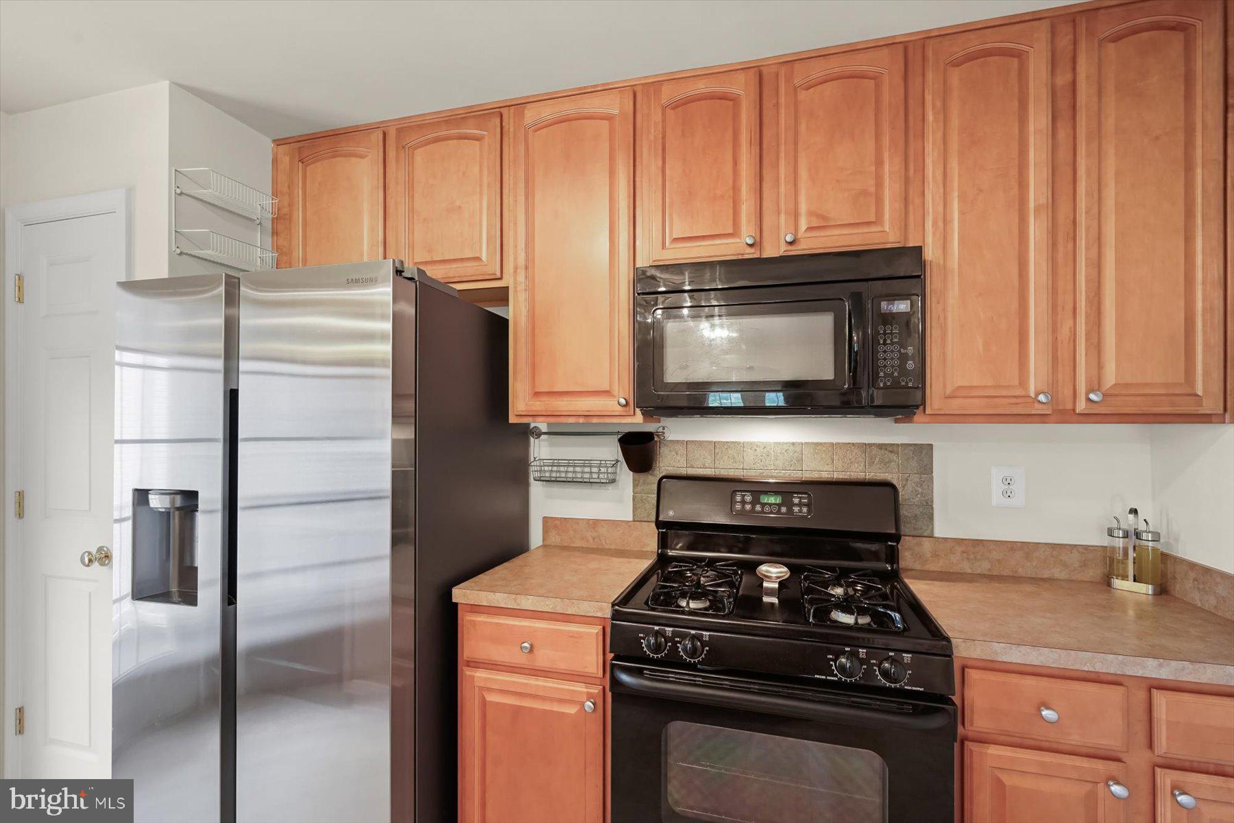 2044 Astilbe Way, Unit 2044 Odenton, MD 21113 - Photo 14 of 56 a kitchen with stainless steel appliances granite countertop a refrigerator stove and microwave
