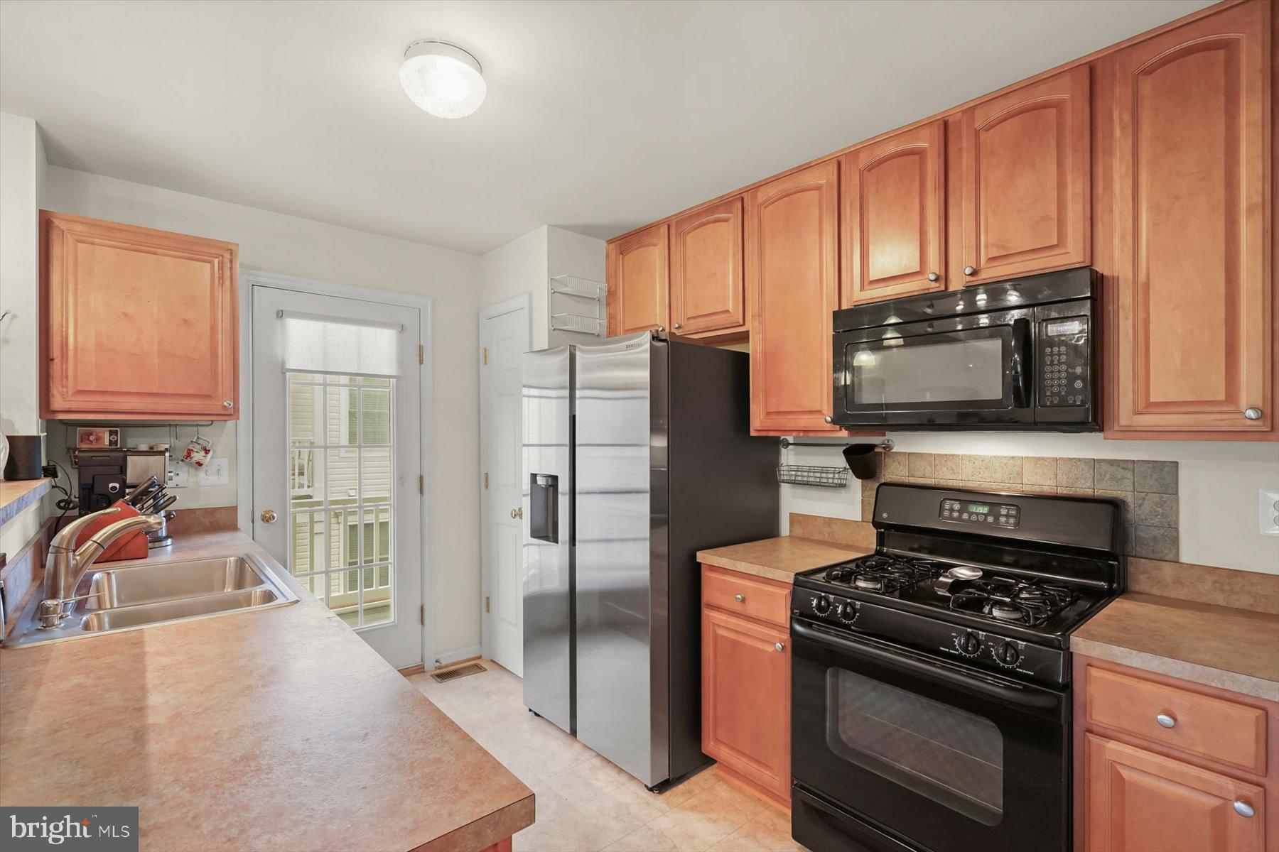 2044 Astilbe Way, Unit 2044 Odenton, MD 21113 - Photo 15 of 56 a kitchen with stainless steel appliances granite countertop a stove refrigerator and microwave