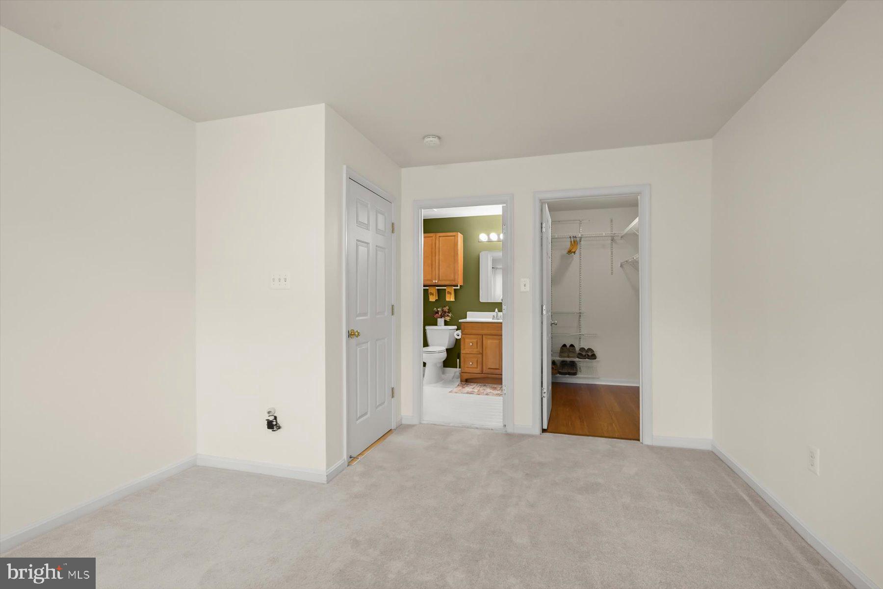 2044 Astilbe Way, Unit 2044 Odenton, MD 21113 - Photo 46 of 56 a view of a livingroom and a hall with wooden floor and a bathroom