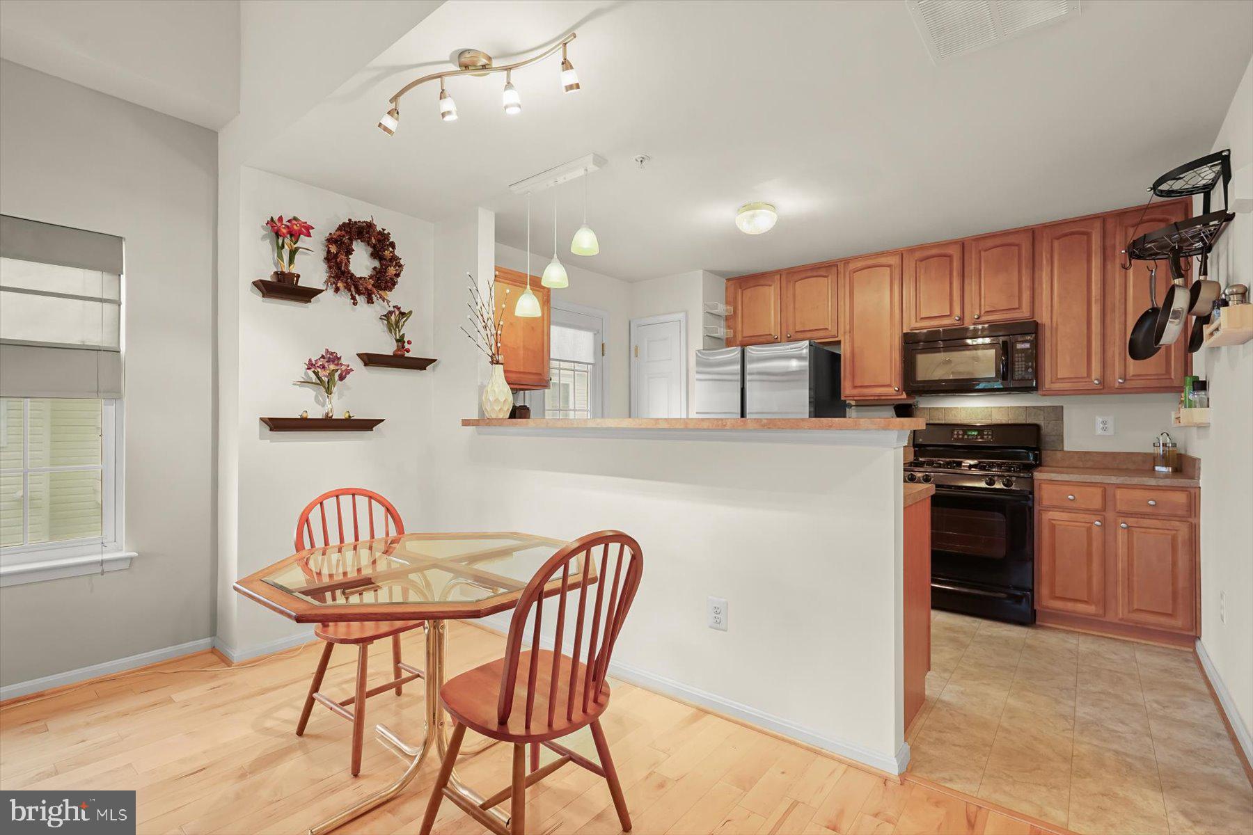 2044 Astilbe Way, Unit 2044 Odenton, MD 21113 - Photo 10 of 56 a kitchen with stainless steel appliances granite countertop a stove top oven a sink a dining table and chairs