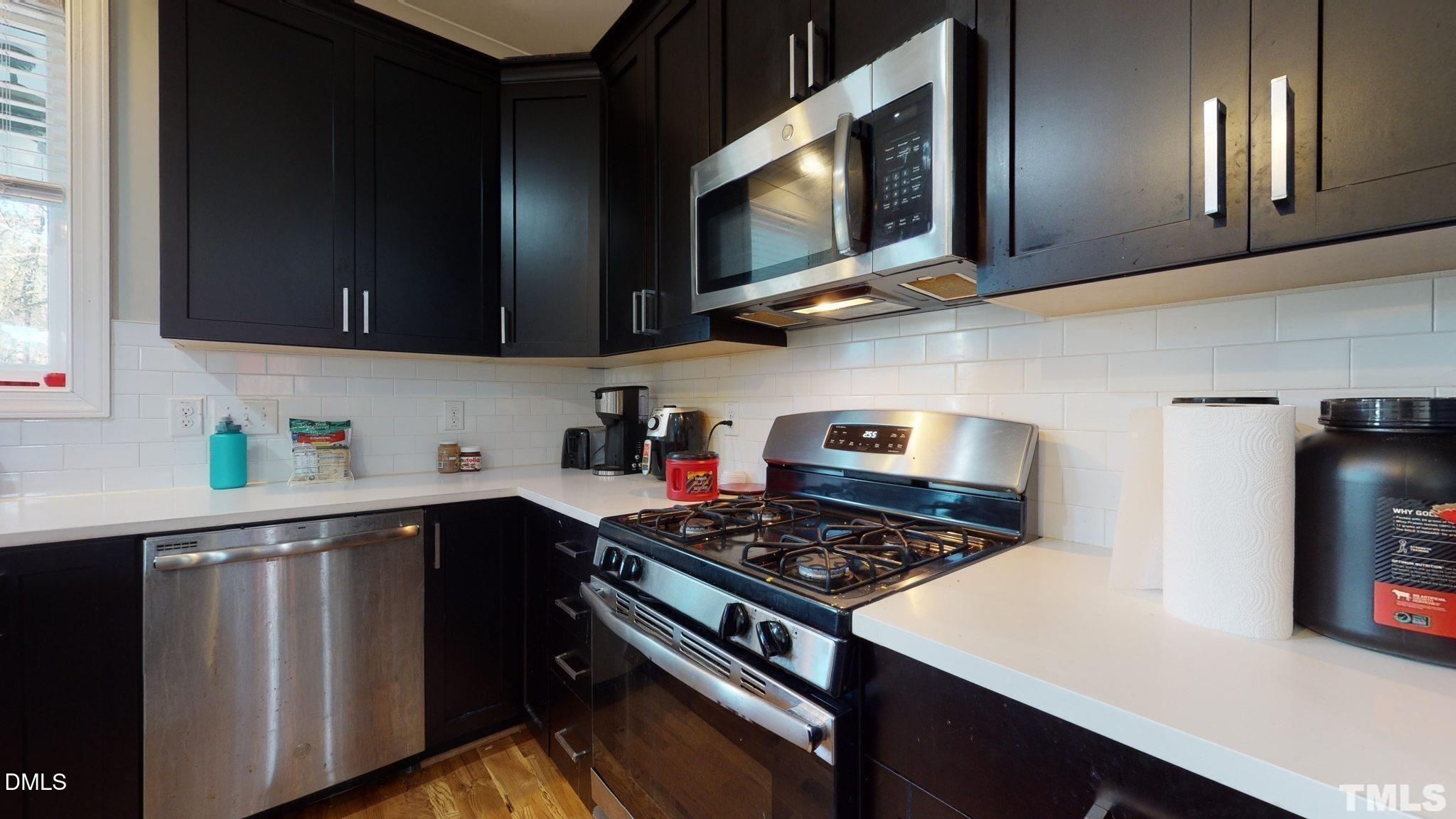 5012 Western Boulevard Raleigh, NC 27606 - Photo 10 of 24 a kitchen with stainless steel appliances a stove a microwave cabinets and a sink