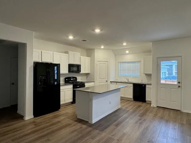 a kitchen with stainless steel appliances granite countertop a refrigerator and a stove top oven