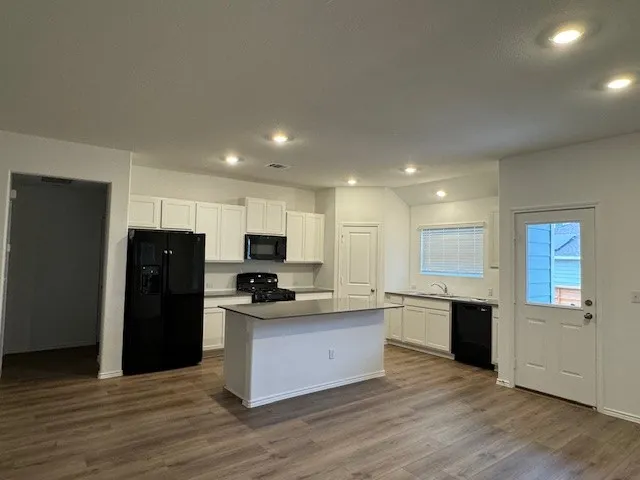 a kitchen with stainless steel appliances granite countertop a refrigerator and a stove top oven