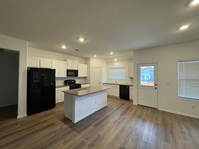 a kitchen with a refrigerator and a stove top oven