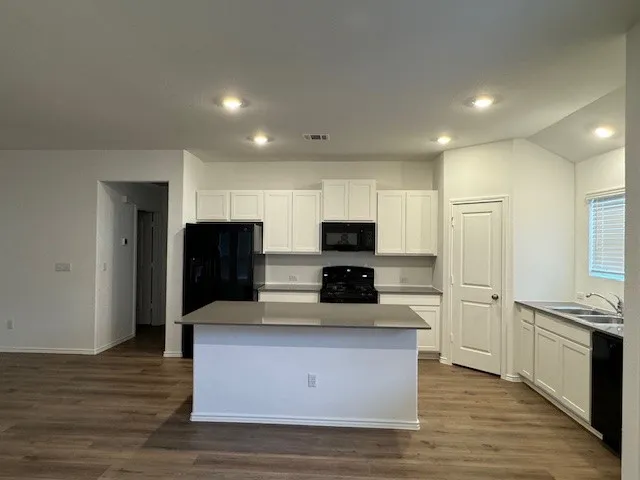 a large kitchen with stainless steel appliances a refrigerator and a stove top oven