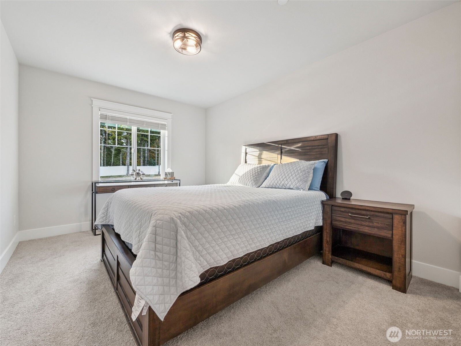 917 Tiedman Road Northwest Lakebay, WA 98349 - Photo 24 of 39 a large bed sitting in a bedroom next to a window with a dresser