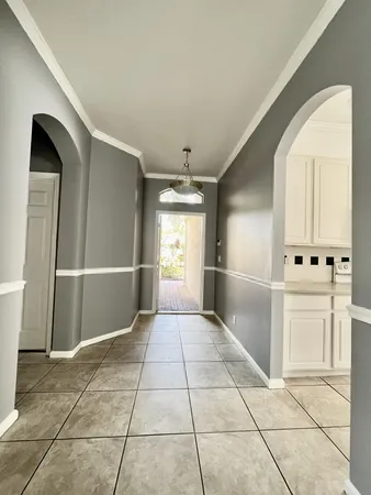 a view of a hallway with white cabinets and entryway