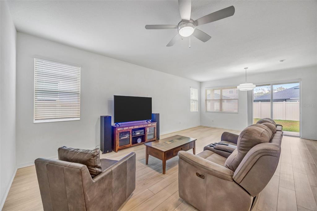 7882 Lennox Loop Wesley Chapel, FL 33544 - Photo 14 of 58 a living room with furniture a flat screen tv and a window