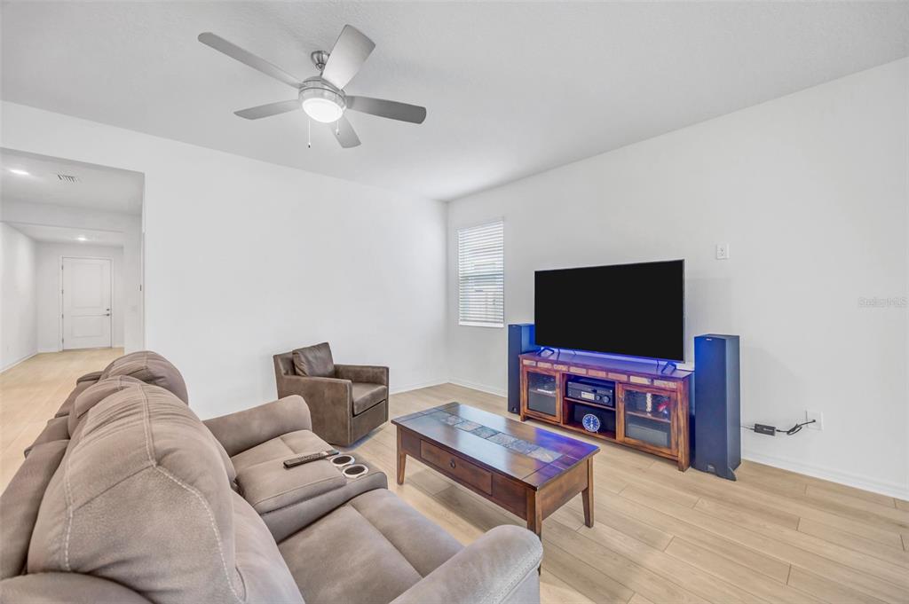 7882 Lennox Loop Wesley Chapel, FL 33544 - Photo 15 of 58 a living room with furniture and a flat screen tv