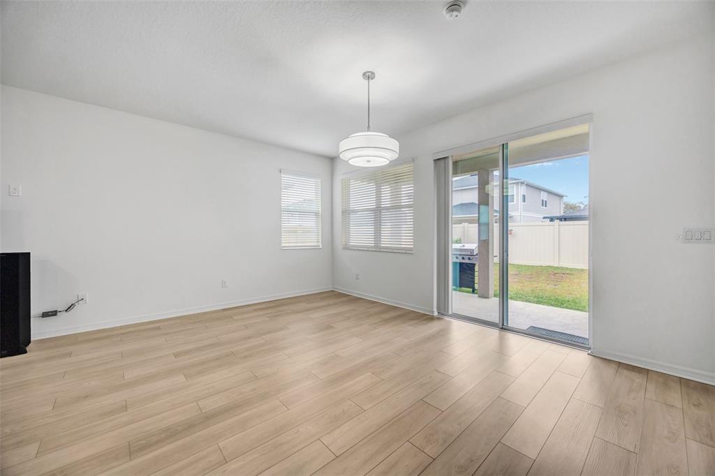 7882 Lennox Loop Wesley Chapel, FL 33544 - Photo 20 of 58 an empty room with wooden floor and windows